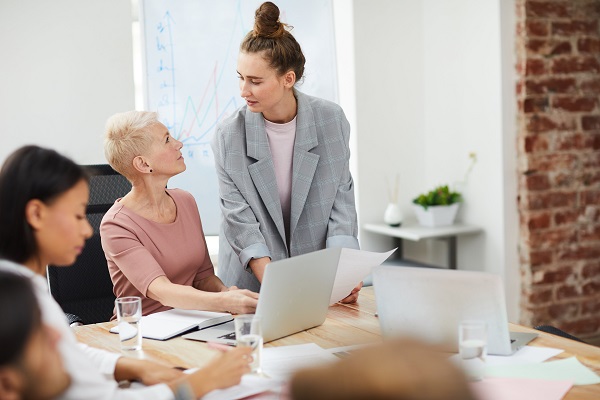 A young woman leader helping out her boss.