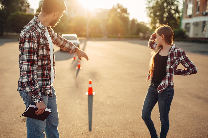 A driving instructor giving tips to his female student
